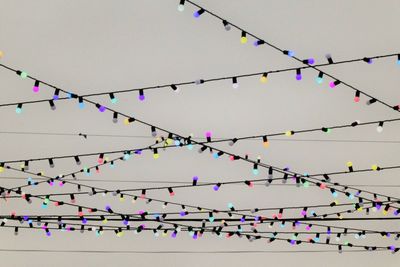 Low angle view of lighting equipment hanging against sky