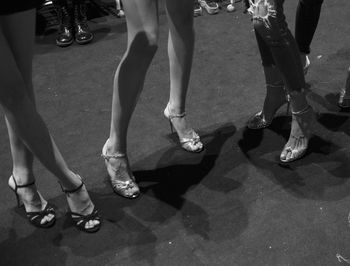 Low section of woman wearing high heels while standing on street