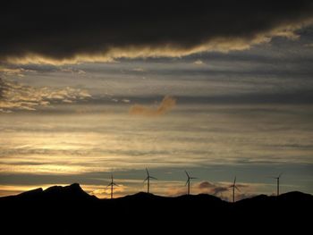 Scenic view of dramatic sky over silhouette landscape