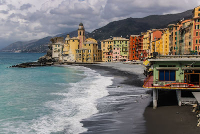 Scenic view of sea by buildings against sky