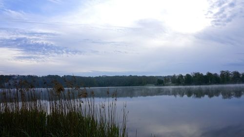 Scenic view of lake against cloudy sky