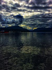 Scenic view of sea against cloudy sky during sunset