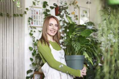 Portrait of young botanist holding plant