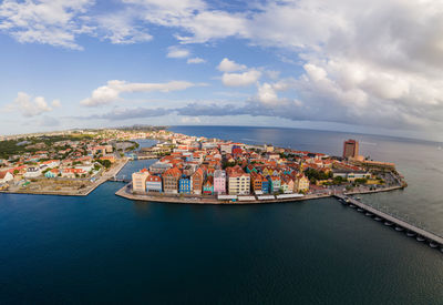 Aerial view of cityscape by sea against sky