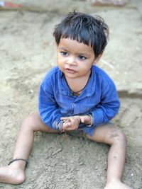 High angle view of baby girl sitting on dirt