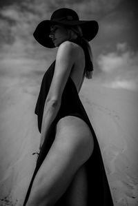 Side view of woman wearing hat at beach