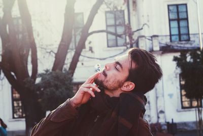 Young man smoking on city street