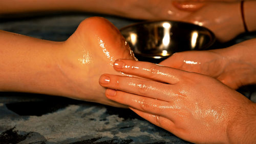 Cropped hands of male masseur massaging female customer at beauty spa