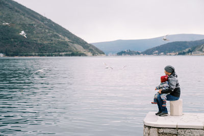 Side view of man standing by lake