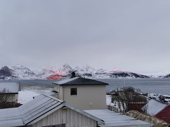 Houses by sea against sky