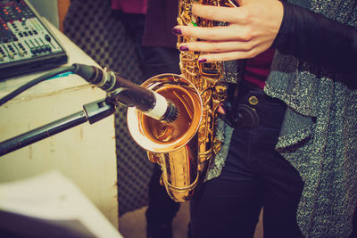 Midsection of woman playing saxophone