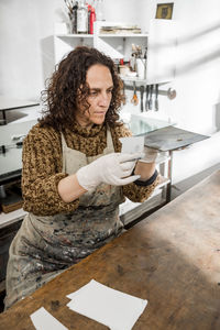 Female artist inspecting a plate and preparing it for a handmade