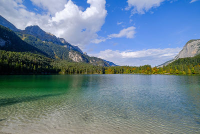 Scenic view of lake by mountains against sky