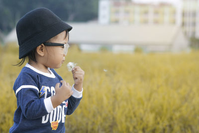 Close-up of boy wearing bucket hat on field