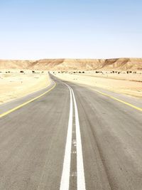 Road passing through landscape against clear sky