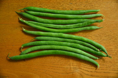 High angle view of green beans on wooden table