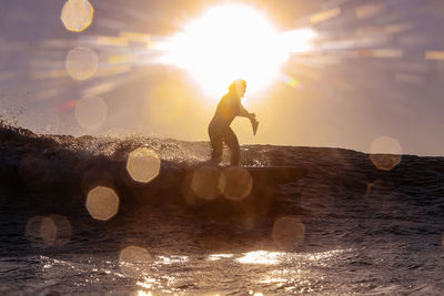 Male sup surfer at sunset time