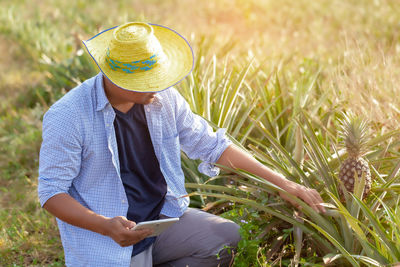 Midsection of woman wearing hat on field