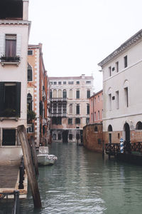 Boats in canal against buildings in city