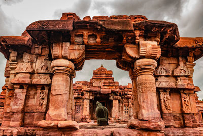 Rear view of old temple against cloudy sky