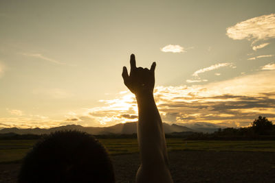 Hand up on sunset sky for love