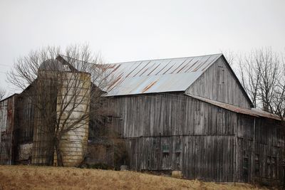 Old barn on field against sky