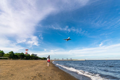 Airplane flying over sea against sky