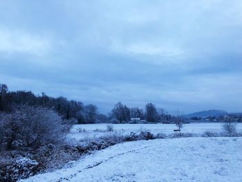 Snow covered field against sky