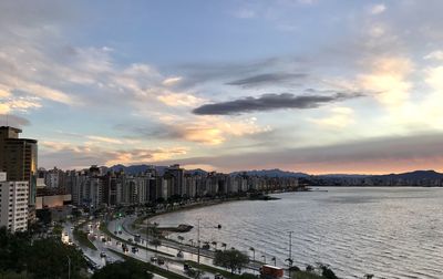 High angle view of city by sea against sky