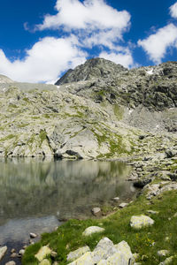 Scenic view of lake by mountains against sky