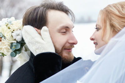 Close-up of couple embracing during wedding ceremony