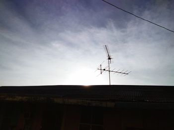 Low angle view of silhouette house against sky during sunset