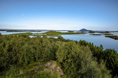 Volcanic lake myvatn with reflections and islands, green meadows and blue skies in northern iceland