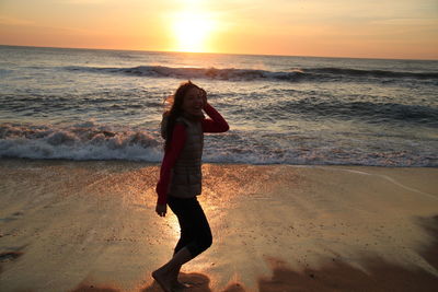 Scenic view of woman and  sea at sunset