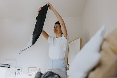 Woman folding clothes in bedroom