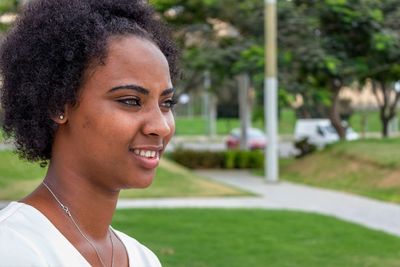 Close-up portrait of a smiling young woman outdoors