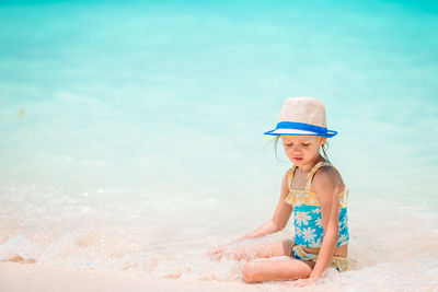 Full length of woman relaxing on beach
