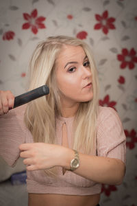 Beautiful woman combing hair at home