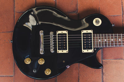 Directly above shot of black guitar on floor