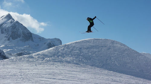 Low angle view of person jumping on mountain