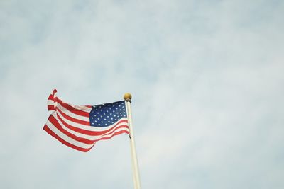 Low angle view of american flag fluttering against sky