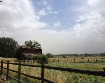 Scenic view of field against cloudy sky