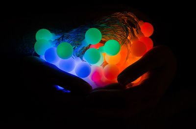 Close-up of illuminated hand over black background