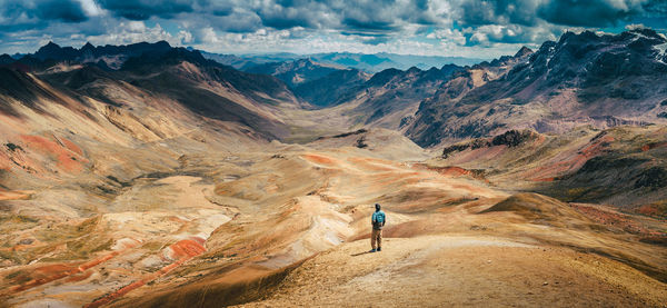 High angle view of man standing at altiplano against cloudy sky