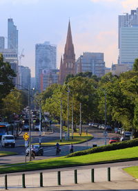 Trees and cityscape against sky