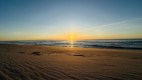 Scenic view of beach against sky during sunset