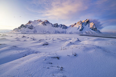 Scenic view of snowcapped mountain against sky during sunset