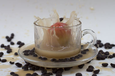 Close-up of drink splashing from cup on table