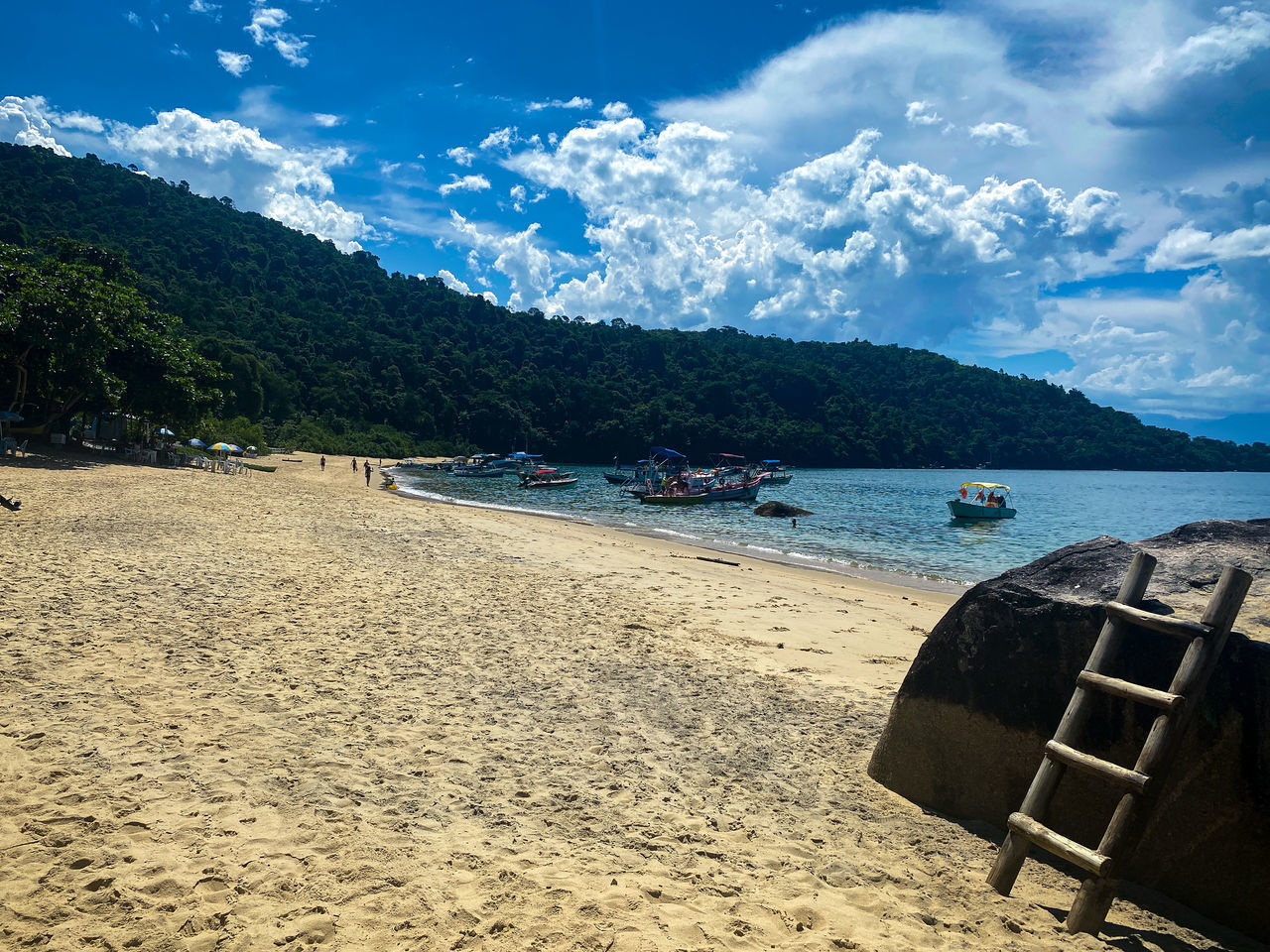 SCENIC VIEW OF BEACH BY MOUNTAINS AGAINST SKY