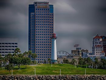 Buildings in city against cloudy sky